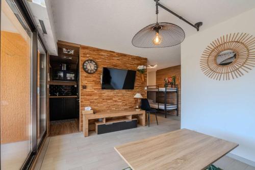 un salon avec une horloge sur un mur de briques dans l'établissement T2- Clim- PLages- Commerces, à Bormes-les-Mimosas