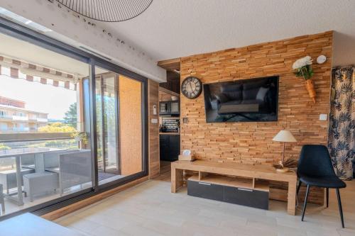 un salon avec un mur en briques et une horloge dans l'établissement T2- Clim- PLages- Commerces, à Bormes-les-Mimosas