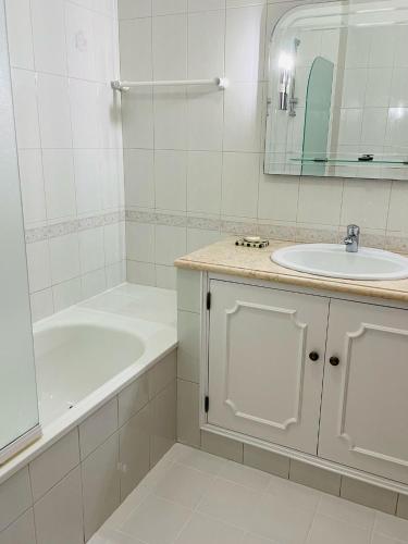 un bagno bianco con vasca e lavandino di Casa Sydney a Lagos