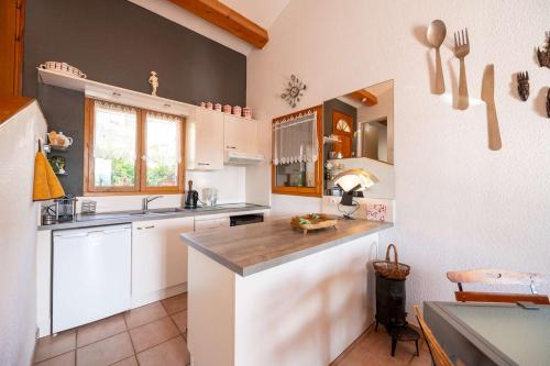 a kitchen with white cabinets and a counter at Maison climatisée pour 5 personnes , au clame , jardin arboré proche commerces in Bormes-les-Mimosas