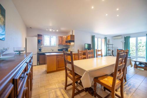une cuisine et une salle à manger avec une table et des chaises dans l'établissement Maison pour 6 personnes , climatisée à 500 m de la plage de Saint Clair, au Lavandou