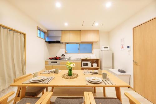 a small kitchen with a wooden table with plates and flowers at MINE HOME東池袋 117t in Tokyo