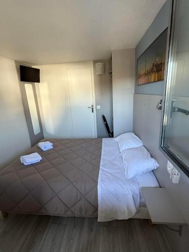 a bedroom with a bed with two towels on it at Fasthotel Roissy - Saint-Witz in Saint-Witz