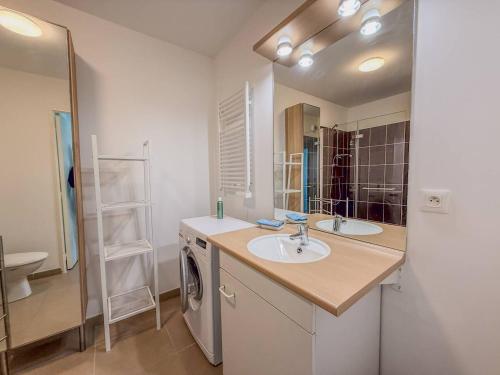 une salle de bain avec un lavabo et une machine à laver dans l'établissement T2 Résidence EDEN, Piscine , Idéale pour une famille de 4 personnes, au Lavandou