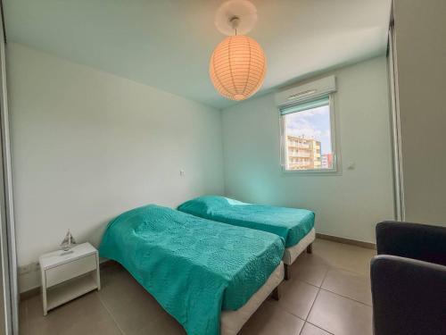 - une chambre avec 2 lits jumeaux et un éclairage dans l'établissement T2 Résidence EDEN, Piscine , Idéale pour une famille de 4 personnes, au Lavandou