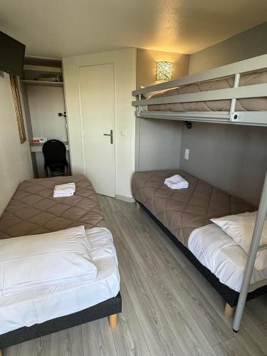 a room with two bunk beds and a chair at Fasthotel Roissy - Saint-Witz in Saint-Witz
