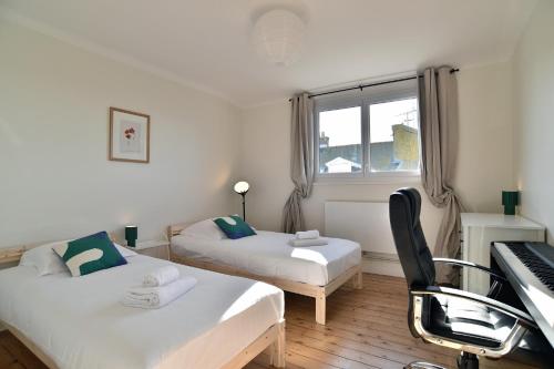 - une chambre avec deux lits et un piano dans l'établissement Le Nid Malouin - A 350 m de la plage, à Saint-Malo