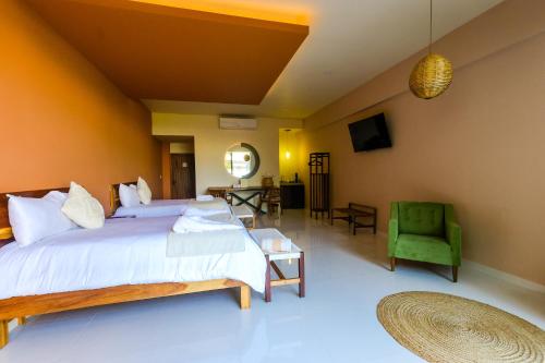 a bedroom with a large bed and a green chair at Hotel Wellness - Belleza y Serenidad in Boca del Río