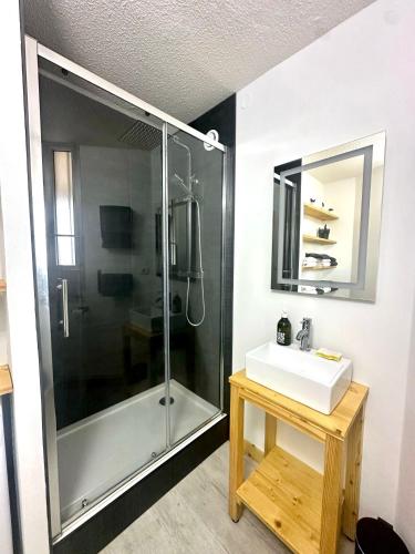une salle de bain avec une douche, un lavabo et un miroir dans l'établissement FREDANNE, appartement moderne wifi, fibre à 100m de la plage, à Canet