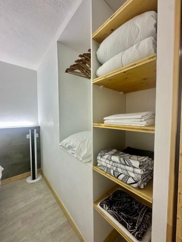 un dressing avec des étagères en bois et des oreillers dans l'établissement FREDANNE, appartement moderne wifi, fibre à 100m de la plage, à Canet