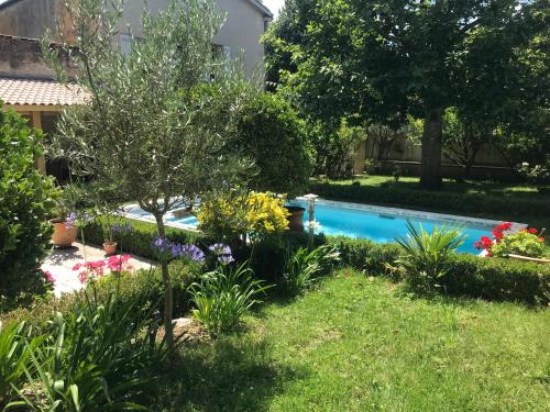 un jardin avec une piscine et quelques fleurs dans l'établissement 3 chambres chez l'habitant, à Salleboeuf