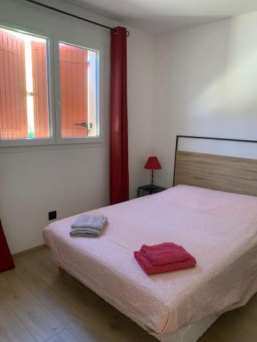 une chambre avec un lit avec deux serviettes dessus dans l'établissement Gîte Lavande Luberon, à Saint-Saturnin-lès-Apt