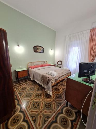 a bedroom with a bed and a desk and a television at Dimora Valicenti in San Giorgio Lucano