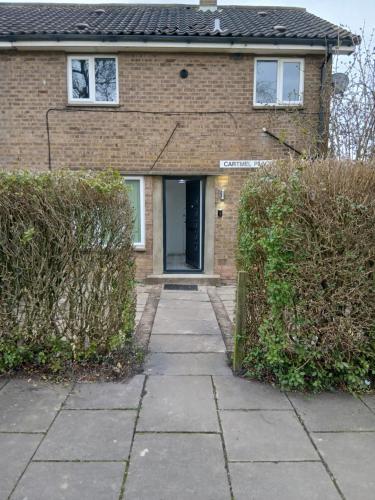 a brick house with a door and two bushes at Newly Refurbed, Driveway, 4-BR House, Ensuite in Northampton
