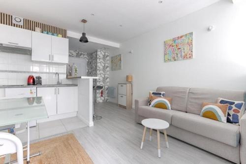 Il comprend un salon avec un canapé gris et une cuisine. dans l'établissement Charming apartment Gambetta - Saint Fargeau II, à Paris