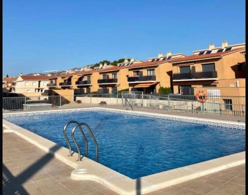 a large swimming pool in front of some buildings at Apartamento familiar con piscina in Miami Platja