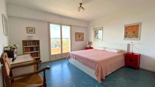 une chambre avec un lit et une grande fenêtre dans l'établissement Le Marbello- Vue mer- Plages- Commerces, au Lavandou