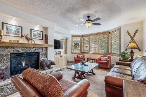 Una sala de estar con muebles de cuero y chimenea. en Torian Plum Creekside 211, en Steamboat Springs