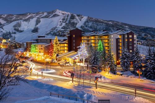 Una ciudad iluminada en la nieve por la noche en Torian Plum Creekside 211, en Steamboat Springs