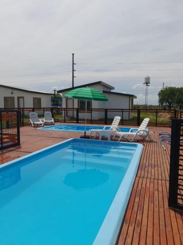 ein großer Pool mit Stühlen und einem Sonnenschirm in der Unterkunft Alojamiento Itati in Colón