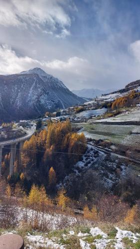 a view of a river with a bridge and mountains at La Vieille Cloche in Saint-Rhémy-en-bosses