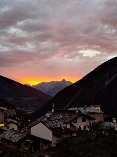 a sunset over a village with mountains in the background at La Vieille Cloche in Saint-Rhémy-en-bosses