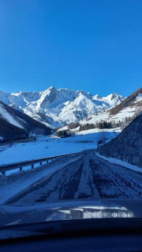 a snow covered road with mountains in the background at La Vieille Cloche in Saint-Rhémy-en-bosses