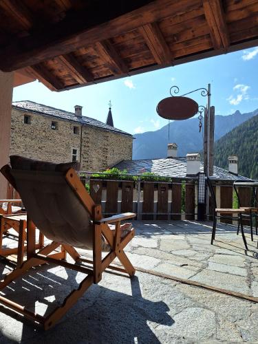 a rocking chair sitting on a patio with a view at La Vieille Cloche in Saint-Rhémy-en-bosses