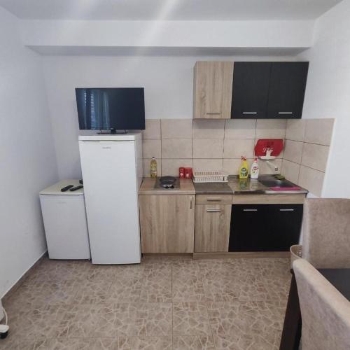 a small kitchen with a refrigerator and a dishwasher at NEWBORN Hostel Budva in Budva