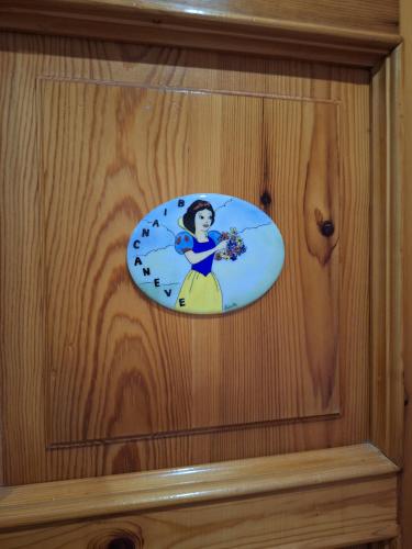 a sticker of a woman on a wooden wall at La Vieille Cloche in Saint-Rhémy-en-bosses