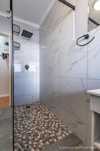 a shower with a glass door in a bathroom at Genoeg in Langebaan