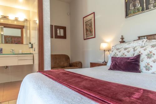 a bedroom with a bed and a sink and a mirror at El Racó de Madremanya - Adults only in Madremanya