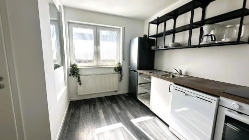 a small kitchen with white cabinets and a window at Geräumige Monteurunterkunft Plus in Lengerich