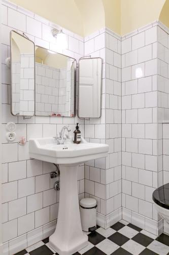 a bathroom with a sink and mirrors and a toilet at Large 2BR in Central Gamla Stan in Stockholm