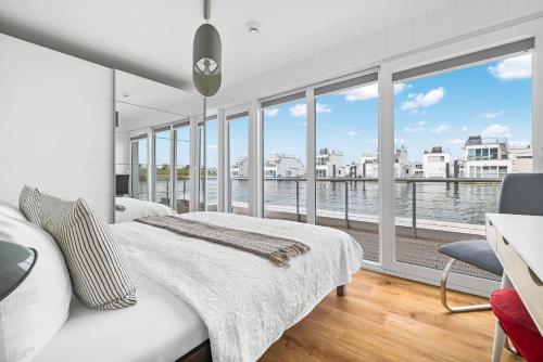 une chambre avec un lit et une vue sur l'eau dans l'établissement Schleikubus – Ihr schwimmendes Ferienparadies im OstseeResort Olpenitz, à Olpenitz