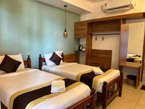 a bedroom with two beds and a room with a bed at Santa Maria - A Premium Boutique Homestay by the Sea I Trivandrum Airport 1mile in Trivandrum