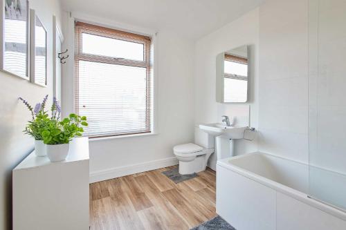 a white bathroom with a toilet and a sink at Host & Stay - Wellington Street in Ripon