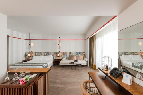 a hotel room with two beds and a living room at Folie Marine Hotel & Beach Club in Jal