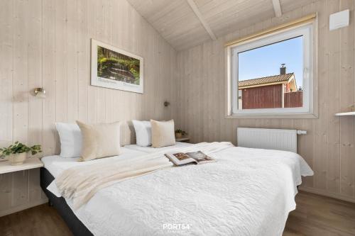 a bedroom with a large white bed with a window at Ferienhaus Spitzenblick 2 - Sankt Andreasberg im Harz in Sankt Andreasberg