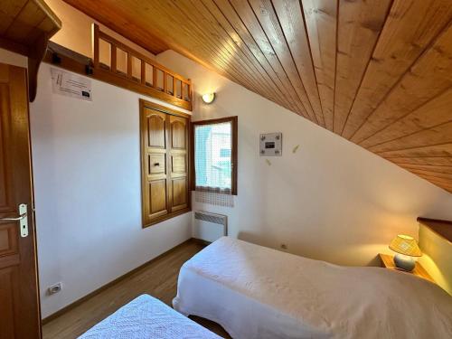 une chambre avec un lit et un plafond en bois dans l'établissement Charmant Duplex de 45m², 2 Chambres, Jardin, Garage, Villard-de-Lans - FR-1-515-51, à Villard-de-Lans