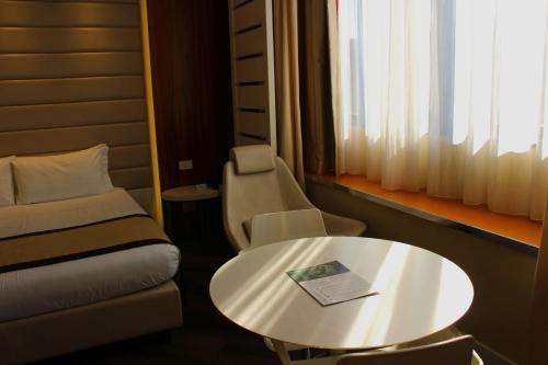 Pokój z łóżkiem, stołem i krzesłem w obiekcie Best Western Mirage Hotel Fiera w mieście Paderno Dugnano