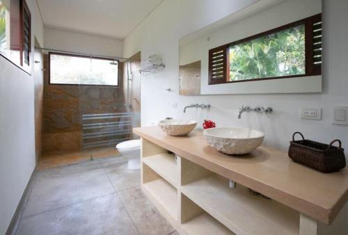 a bathroom with two sinks on a counter with a toilet at Astonishing 5BR House with pool in Anapoima in Anapoima