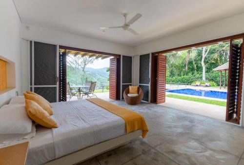a bedroom with a bed and a view of a pool at Astonishing 5BR House with pool in Anapoima in Anapoima