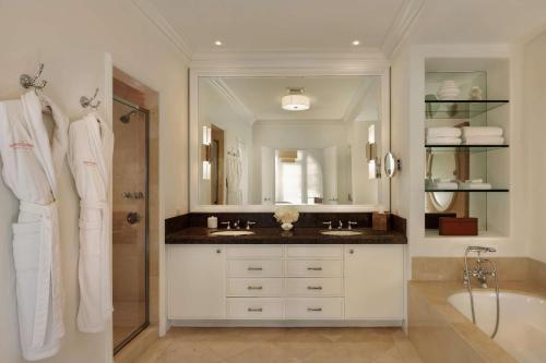 a bathroom with a sink and a tub and a mirror at The Maybourne Beverly Hills, Maybourne in Los Angeles