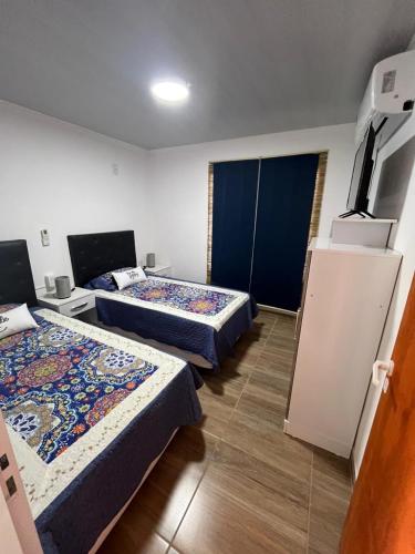 ein Hotelzimmer mit zwei Betten und einem Fernseher in der Unterkunft Alojamiento Itati in Colón