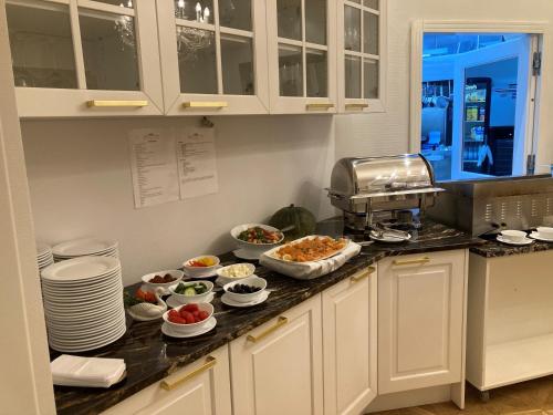 a kitchen with dishes of food on a counter at Kurhaus Bad Doberan in Bad Doberan