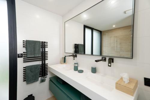 une salle de bain avec un lavabo et un miroir dans l'établissement Villa Élisa, à Saint-Malo