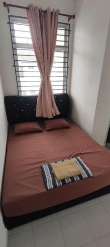 a bed in a room with a window at Arif & Asna Family's HOMESTAY in Pasir Mas