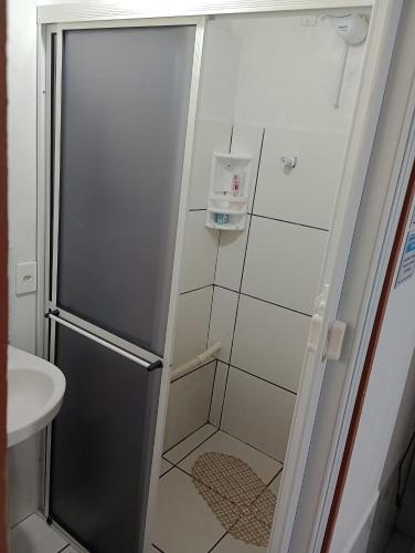 a shower with a glass door next to a sink at Cantinho do lar in Timbó