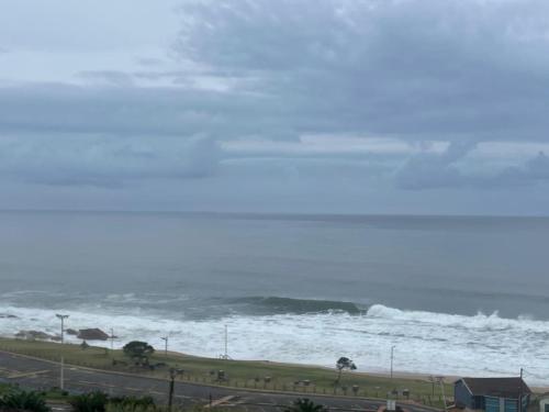 a beach with a large wave in the ocean at Peacehaven 406 in Scottburgh
